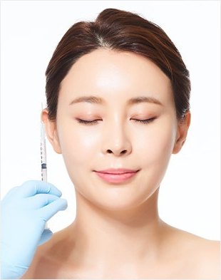눈을 감은 여성의 얼굴 옆에서 파란 장갑을 낀 손이 턱 근육에 주사기를 대고 있는 사각턱 보톡스 이미지