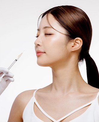눈을 감고 고개를 든 여성의 옆얼굴에 주사기를 가까이 댄 국산 보톡스 시술 이미지