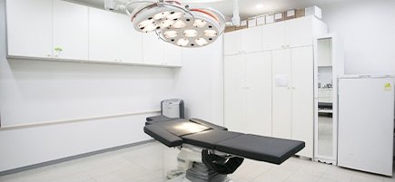 무영등과 시술 베드가 놓인 흰색 시술실 전경
