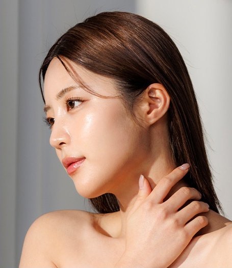측면을 바라보며 목선에 손을 얹은 여성 모델