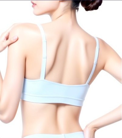 연하늘색 스포츠 브라를 입은 젊은 여성의 뒷모습, 오른손을 왼쪽 어깨에 얹고 고개를 왼쪽으로 살짝 돌린 반측면