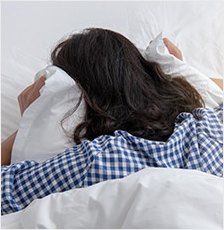 침대에 엎드려 누운 여성의 뒷모습