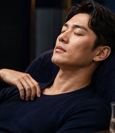 리클라이너에 기대어 눈을 감고 휴식을 취하는 남성