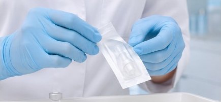 장갑을 낀 손이 개별 포장된 1회용 시술 팁을 개봉하는 모습